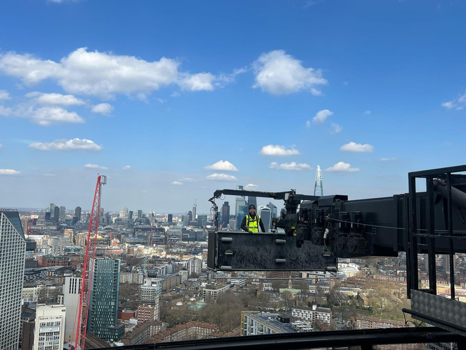 Technician in a crane basket above the London skyline