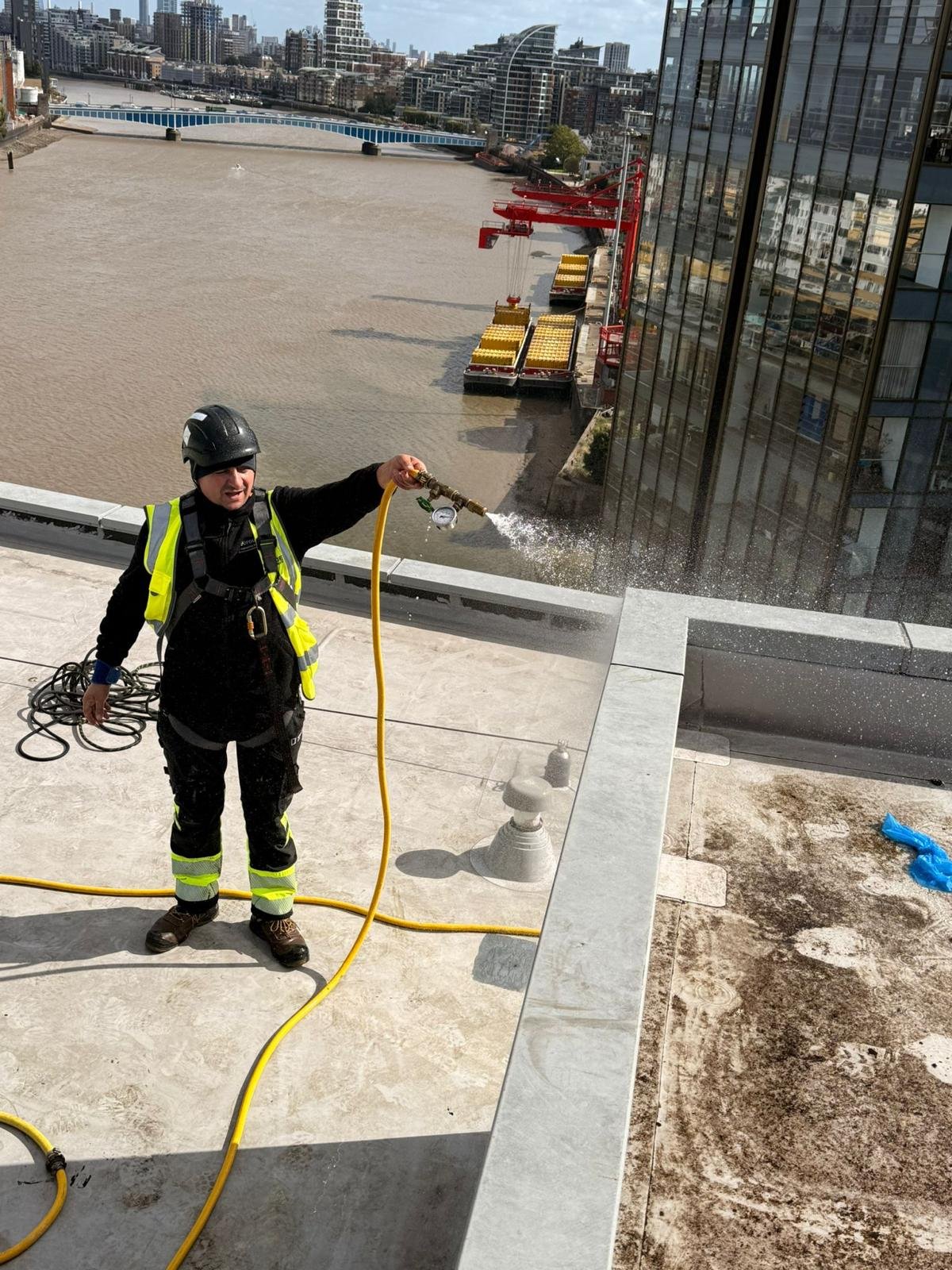 Technician water-testing a façade above the River Thames